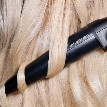 Black hair straightener being used on blonde hair